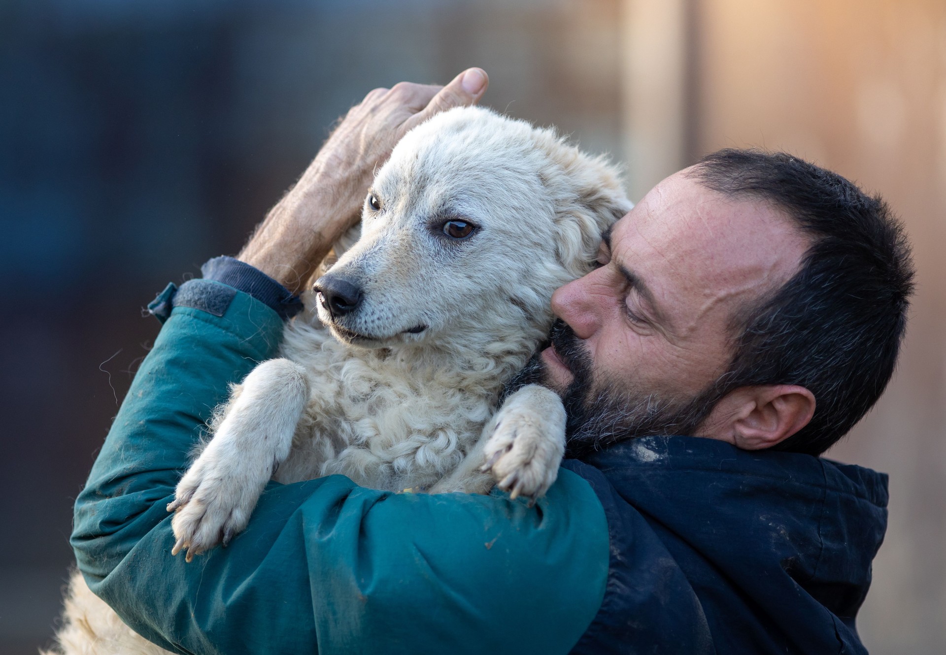 Man holding and hugging dog in shelter