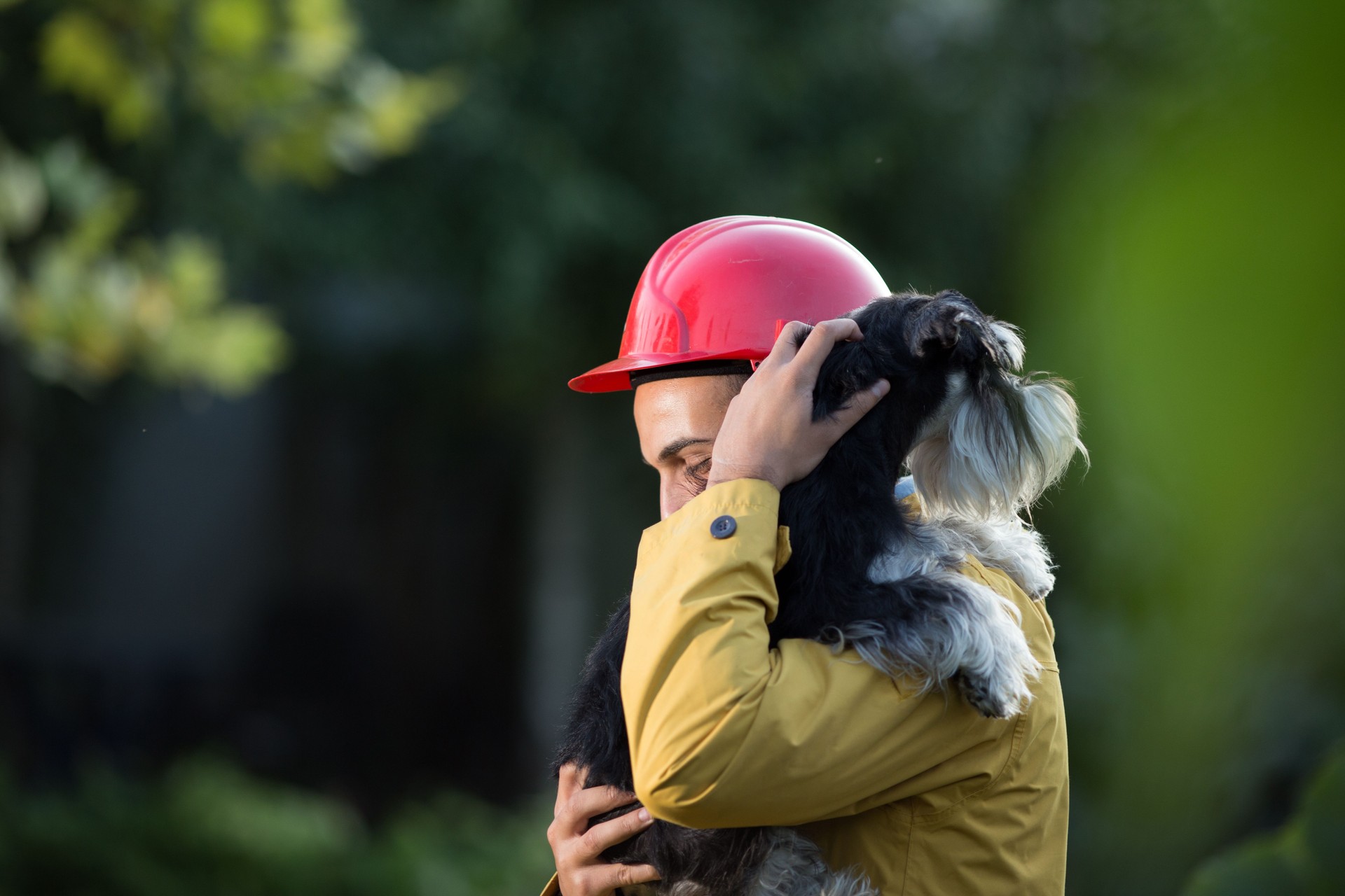 Man in raincoat holding dog
