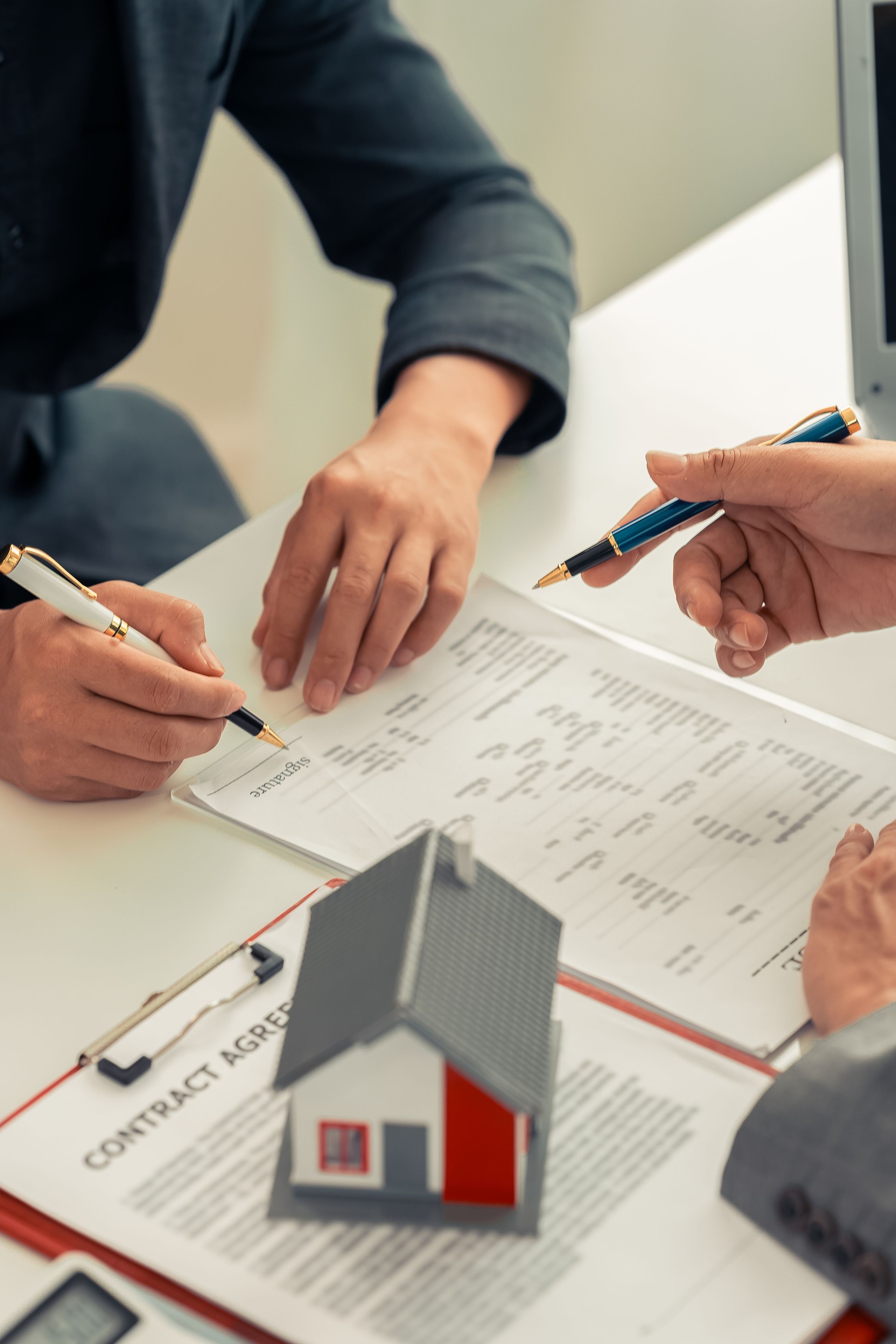 A real estate agent discusses the terms of a home purchase contract and asks the client to sign a document to sign a real estate contract to seek advice on the home he will buy to start a family.
